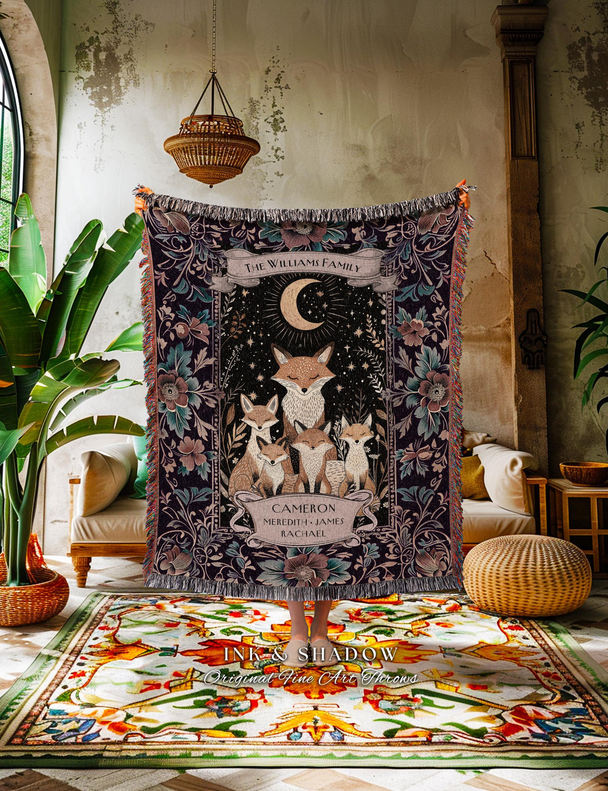 May include: A personalized woven throw blanket featuring a family of foxes under a crescent moon and stars. The dark background is adorned with floral patterns and the text "THE WILLIAMS FAMILY". The names "CAMERON, MEREDITH, JAMES, RACHAEL" are also displayed.