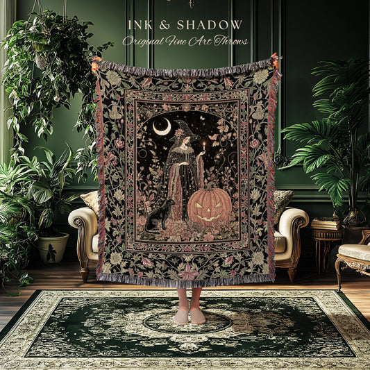 May include: A decorative throw blanket featuring a witch with a black cat and a jack-o'-lantern. The throw has a black background with floral and botanical patterns, and the text "INK & SHADOW Original Fine Art Throws". The blanket is fringed.