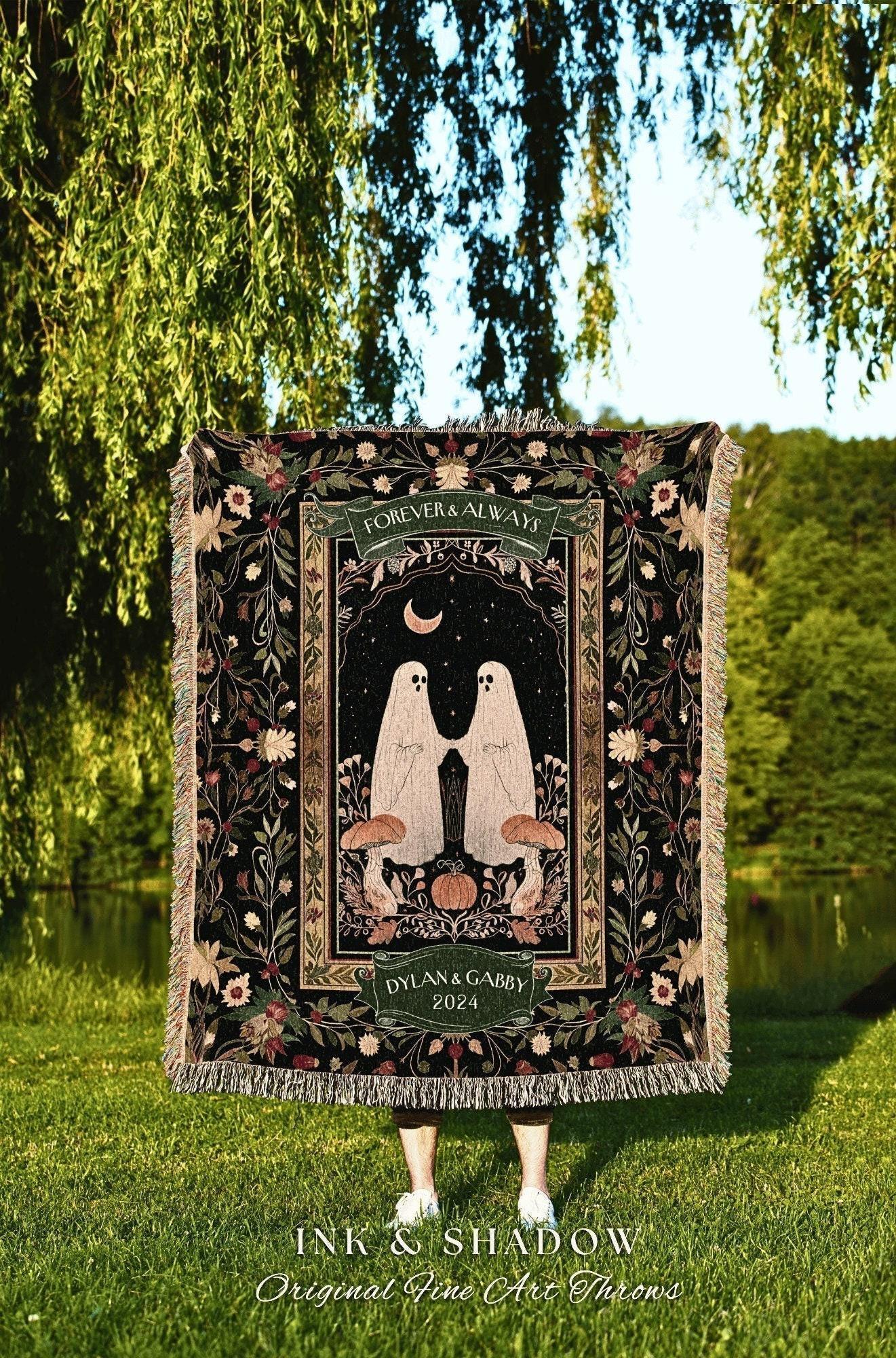 May include: A black throw blanket with a central design featuring two ghost figures holding hands under a crescent moon. The blanket has a floral border and the words "FOREVER & ALWAYS" and "DYLAN & GABBY 2024". The blanket has a fringed edge.