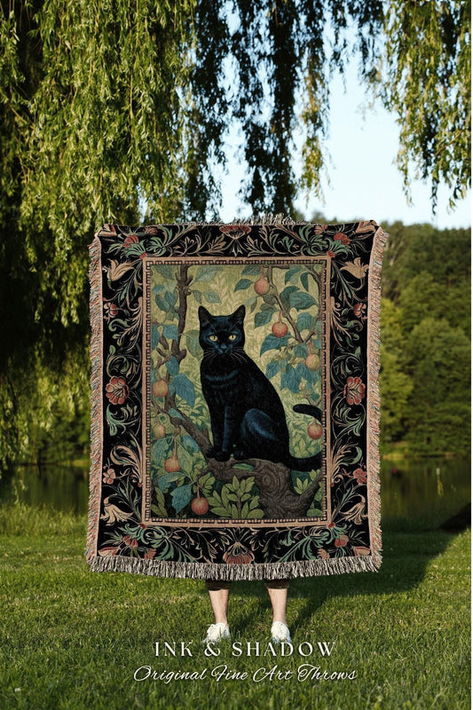May include: A black throw blanket featuring a black cat perched on a tree branch with fruit. The blanket has a black border with floral and leaf designs and fringe. The text "INK & SHADOW Original Fine Art Throws" is at the bottom.