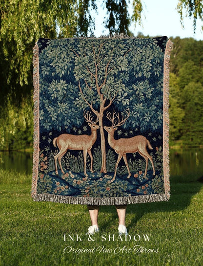 May include: A dark blue throw blanket featuring a tree and two deer facing each other. The blanket has a fringed edge and the text "INK & SHADOW Original Fine Art Throws" at the bottom.