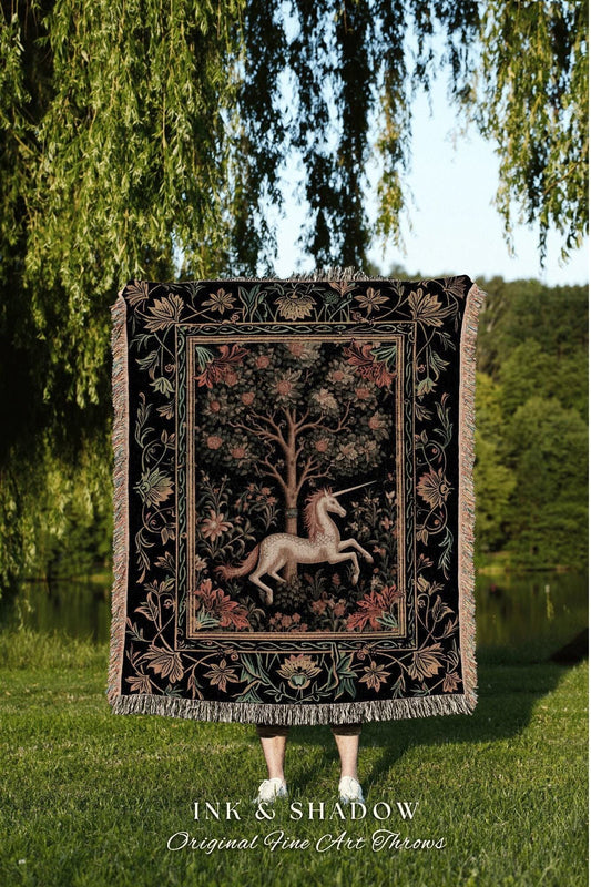 May include: Black tapestry throw blanket featuring a unicorn in a forest scene. The throw has a detailed floral border and fringe. The text "INK & SHADOW Original Fine Art Throws" is at the bottom.