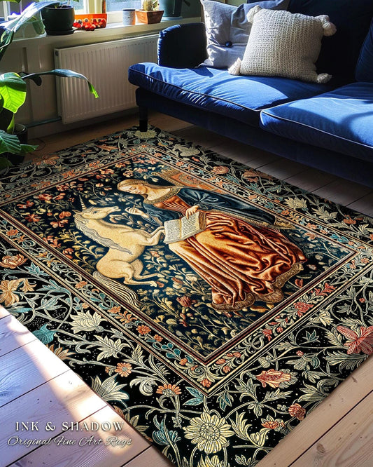 May include: A rectangular area rug with a detailed tapestry design featuring a unicorn, a woman, and floral patterns in shades of blue, brown, and gold. The rug is placed on a wooden floor, with a blue sofa in the background. The text "INK & SHADOW Original Fine Art Rugs" is visible.