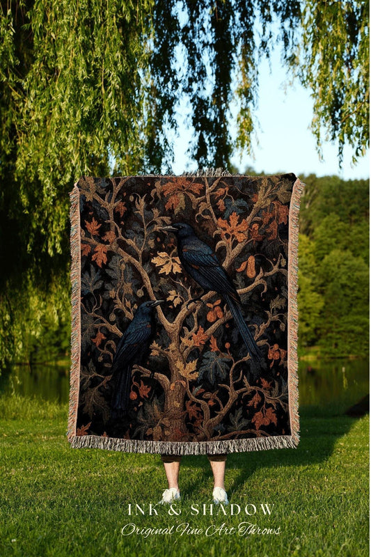 May include: A dark-colored throw blanket featuring a detailed illustration of two black crows perched on a tree with autumn leaves. The blanket has a fringed edge and the text "INK & SHADOW Original Fine Art Throws" at the bottom.
