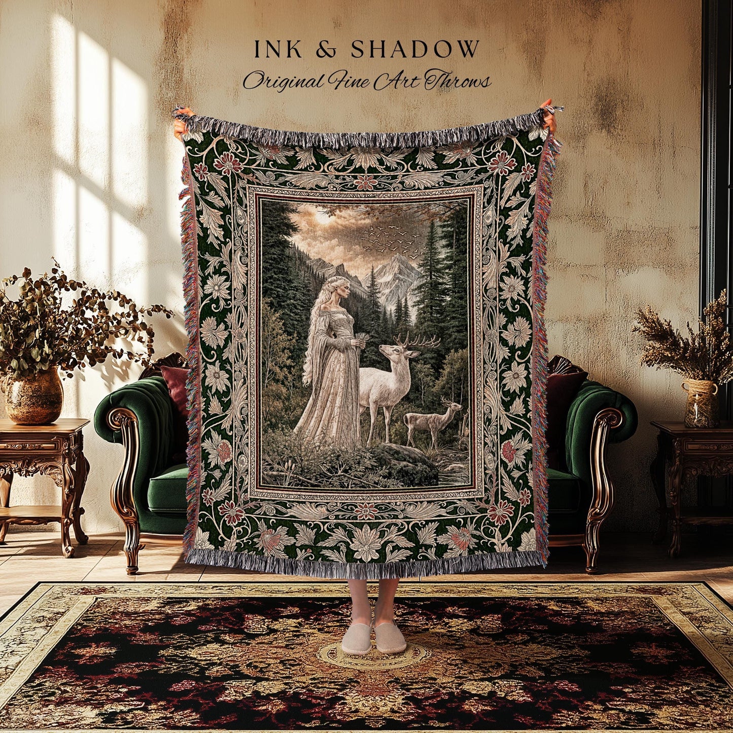 May include: A tapestry throw blanket with a detailed forest scene featuring a woman, deer, and mountains. The blanket has a dark green border with floral patterns and fringe. The text "INK & SHADOW Original Fine Art Throws" is at the top.
