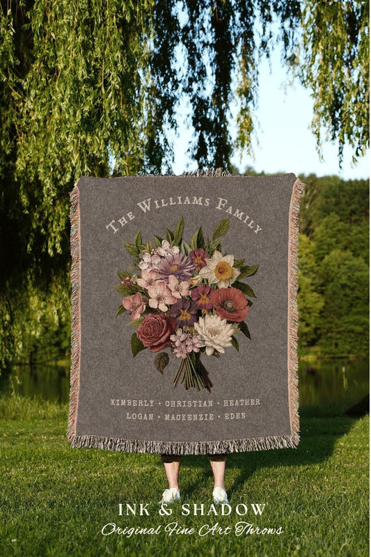 May include: A gray throw blanket with a floral bouquet design and the text "THE WILLIAMS FAMILY". The names KIMBERLY, CHRISTIAN, HEATHER, LOGAN, MACKENZIE, and EDEN are also printed on the blanket. The blanket has a fringed edge.