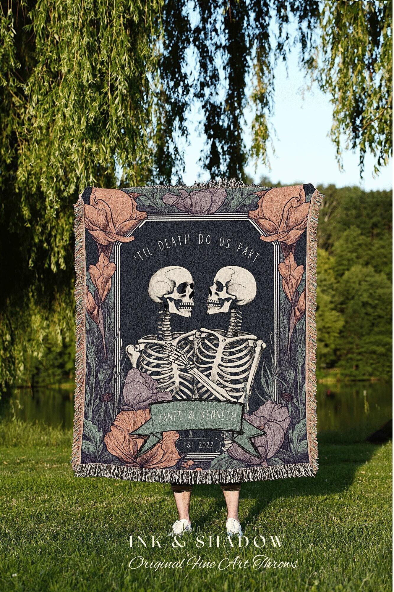 May include: A dark blanket featuring a design with two skeletons embracing, with the text "'TIL DEATH DO US PART". The blanket includes floral accents and the names "JANET & KENNETH" with "EST. 2022".