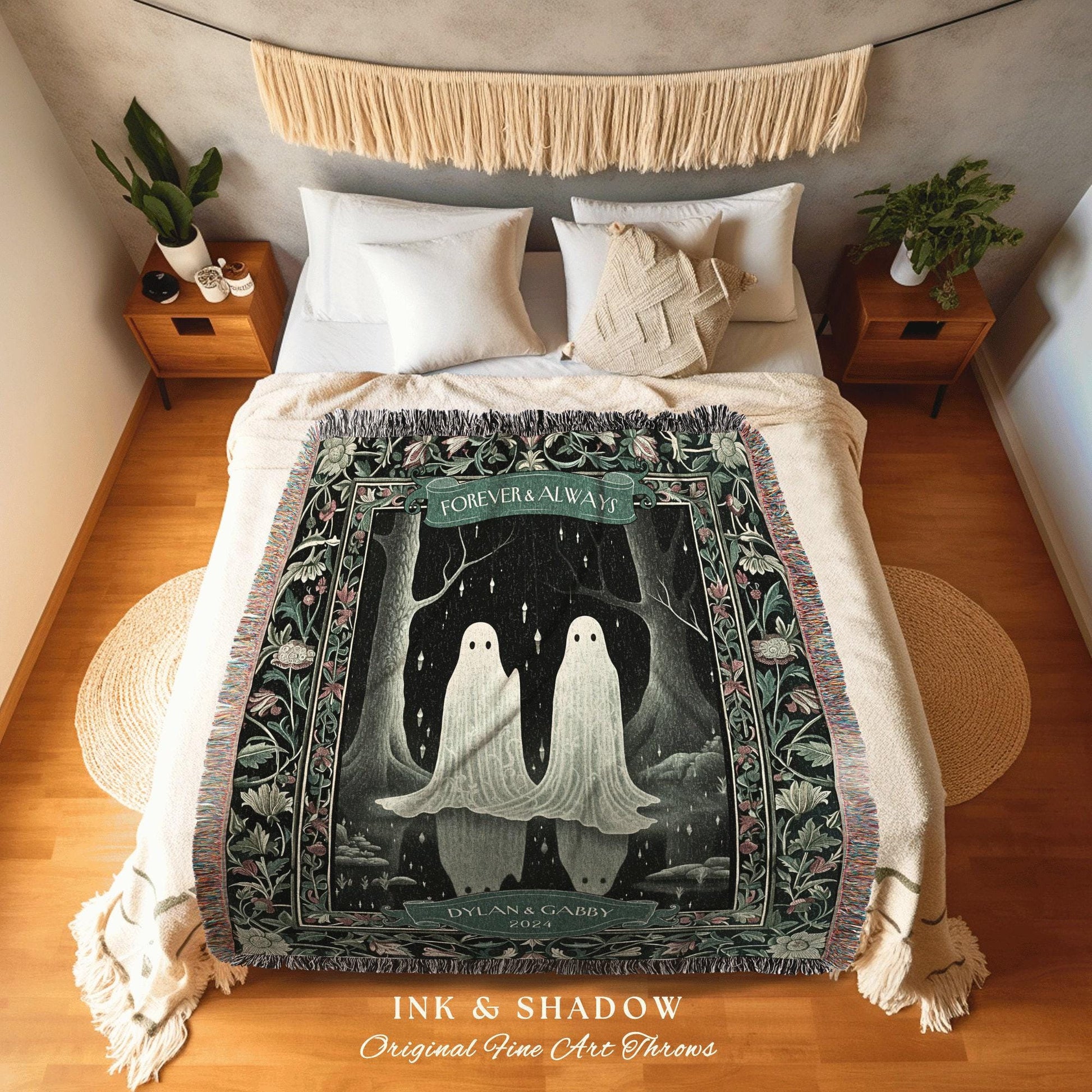 May include: A woven throw blanket featuring a whimsical illustration of two ghost figures under a banner that reads "Forever & Always." The design includes a dark forest scene with floral borders. The blanket is displayed on a bed with white bedding.