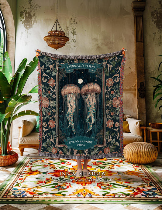 May include: A dark teal throw blanket with a jellyfish design, floral borders, and the text "Eternally Yours" and "Dylan & Gabby 2024." The blanket has a fringed edge and is displayed in a room with a patterned rug and plants.