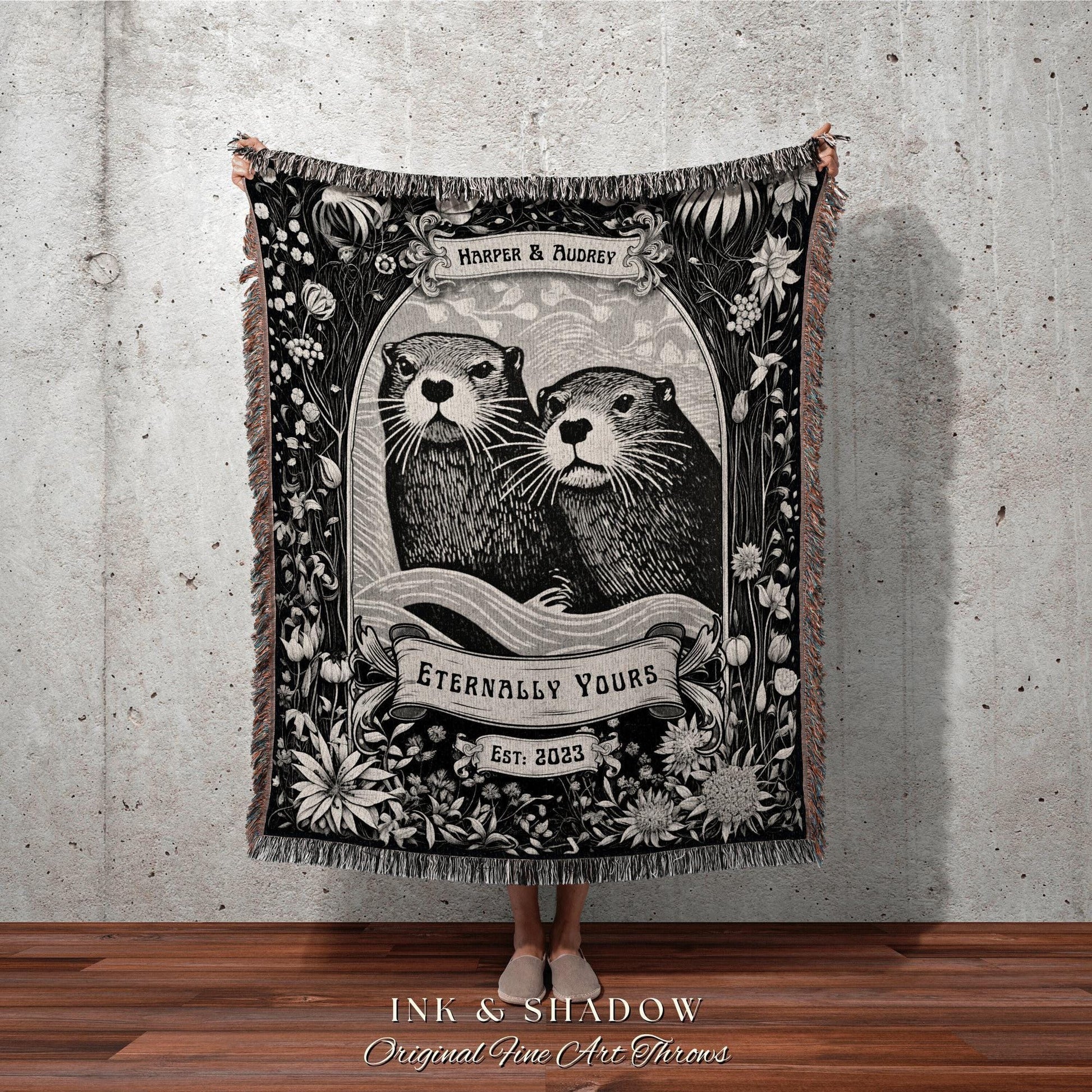 May include: Black and white throw blanket featuring an illustration of two otters within a floral frame. The blanket includes the text "HARPER & AUDREY", "ETERNALLY YOURS", and "EST: 2023". The bottom of the blanket reads "INK & SHADOW Original Fine Art Throws".