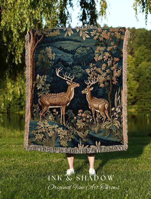 May include: A tapestry throw blanket featuring a forest scene with two deer. The blanket has a dark blue background with brown and green details. The text "INK & SHADOW Original Fine Art Throws" is at the bottom.