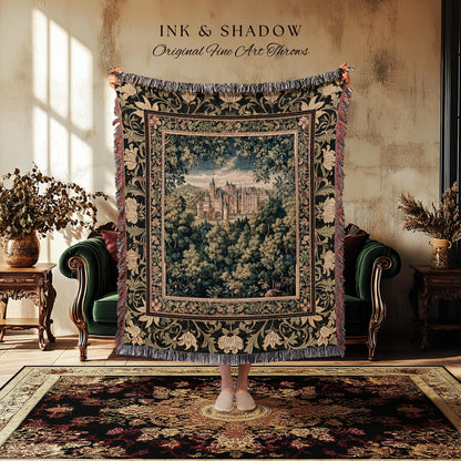 May include: A tapestry throw blanket with a castle scene framed by a floral border. The throw is dark green with cream and red accents, and the text "INK & SHADOW Original Fine Art Throws" is at the top.