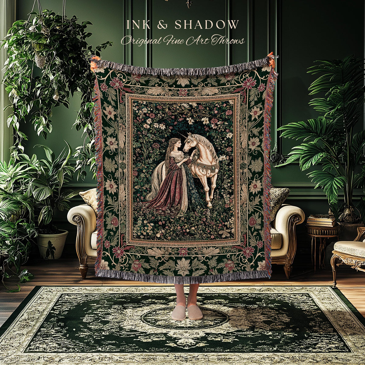 May include: A tapestry throw blanket featuring a medieval scene with a woman and a unicorn. The throw has a dark green background with floral and foliage patterns, and a fringed edge. The text "INK & SHADOW Original Fine Art Throws" is at the top.