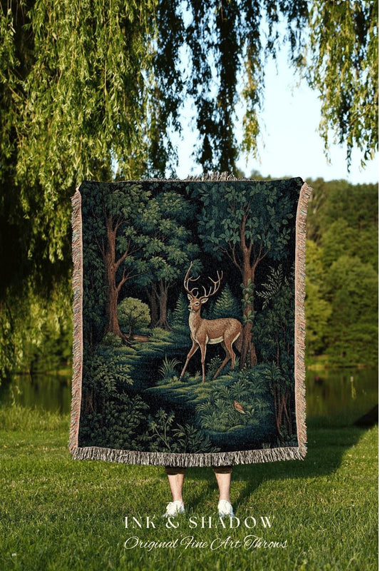 May include: A dark green tapestry throw blanket featuring a forest scene with a deer. The blanket has a fringed edge and the text "INK & SHADOW Original Fine Art Throws" at the bottom.