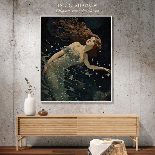 May include: A framed art print featuring a vintage illustration of a woman with long auburn hair, floating in dark water with stars. The artwork is titled "INK & SHADOW Original Fine Art Throws". The print is displayed above a wooden cabinet.