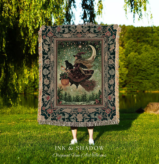 May include: A tapestry throw blanket featuring a witch on a broomstick with a black cat, a pumpkin, and a crescent moon. The throw has a dark green border with floral and leaf patterns, and the text "INK & SHADOW Original Fine Art Throws".