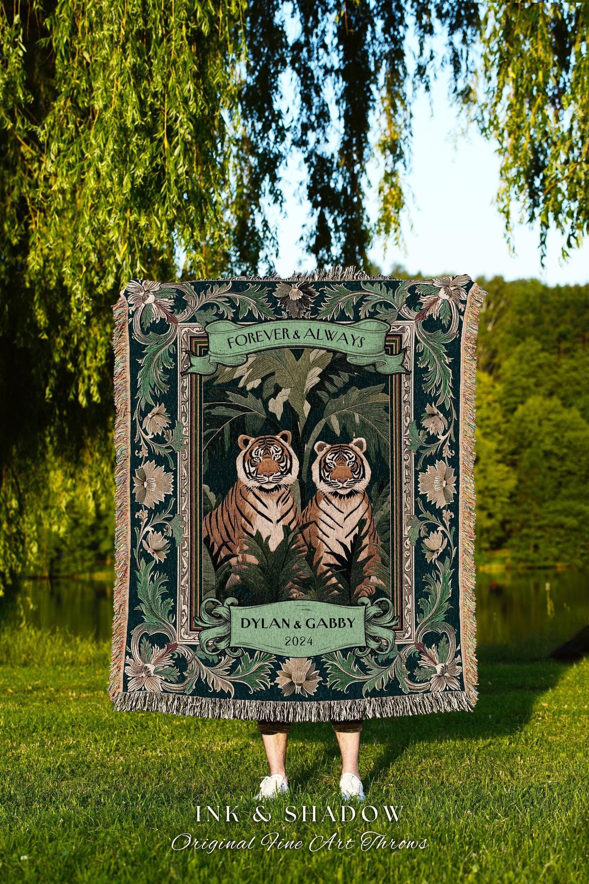 May include: A dark green throw blanket featuring two tigers in a jungle scene, with the words "FOREVER & ALWAYS" and "DYLAN & GABBY 2024". The blanket has a decorative border and fringe, with the text "INK & SHADOW Original Fine Art Throws".