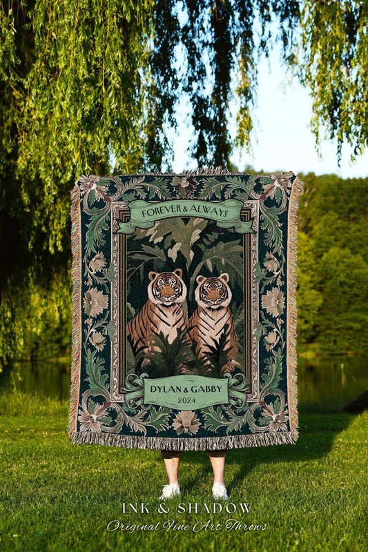 May include: A dark green throw blanket featuring two tigers in a jungle scene, with the words "FOREVER & ALWAYS" and "DYLAN & GABBY 2024". The blanket has a decorative border and fringe, with the text "INK & SHADOW Original Fine Art Throws".