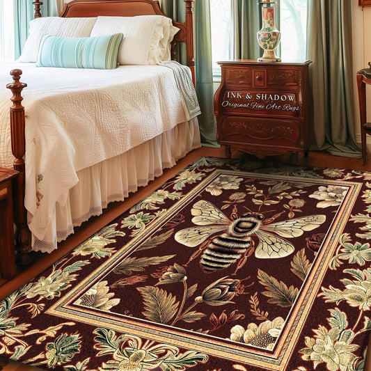 May include: A rectangular area rug with a burgundy background and a detailed bee and floral design. The rug features a large bee in the center with cream-colored wings and a striped body. The border has a cream and gold trim with floral and leaf patterns. The text "INK & SHADOW Original Fine Art Rugs" is visible.