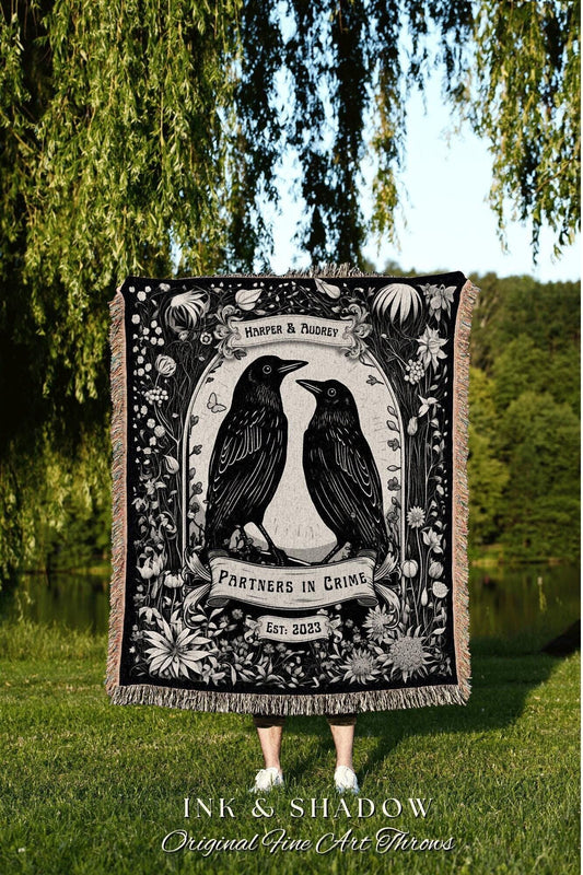 May include: Black and white woven throw blanket featuring two crows facing each other, surrounded by floral elements. The blanket has the text "HARPER & AUDREY", "PARTNERS IN CRIME", and "EST: 2023". The bottom of the blanket has the text "INK & SHADOW Original Fine Art Throws".