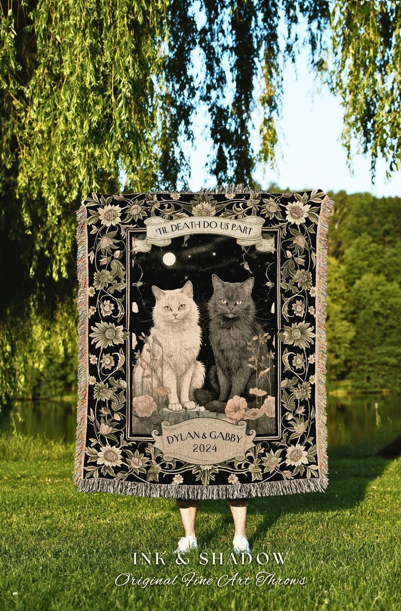 May include: A black throw blanket featuring two cats, a light-colored cat and a dark gray cat, with the text "TIL DEATH DO US PART" and "DYLAN & GABBY 2024". The blanket has a floral border and the words "INK & SHADOW Original Fine Art Throws".