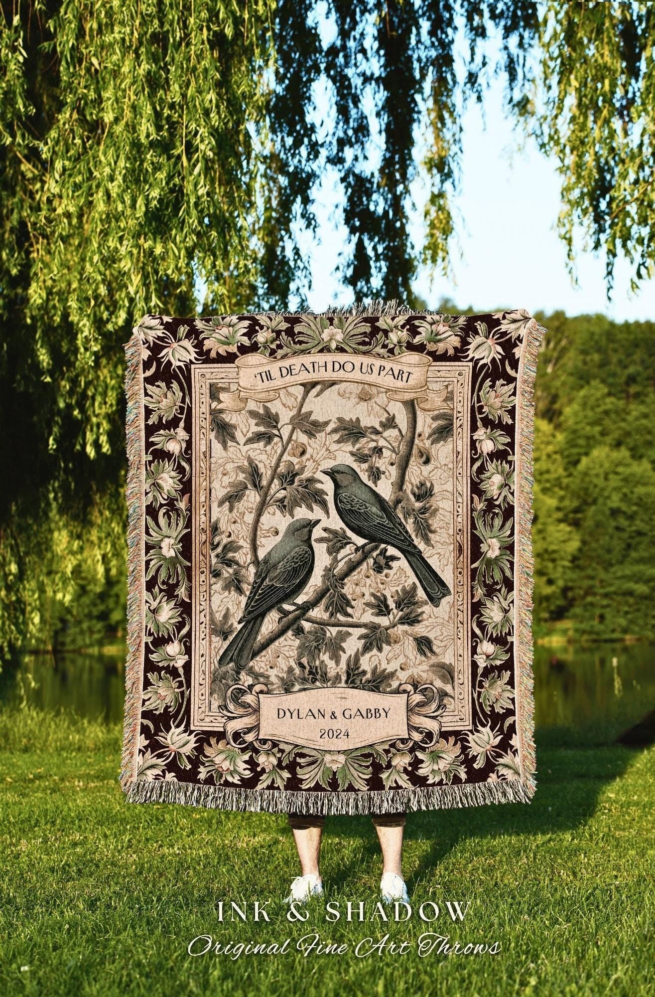 May include: A decorative throw blanket with a detailed design featuring two birds perched on a branch, with the text "TIL DEATH DO US PART" and the names "DYLAN & GABBY 2024". The blanket has a fringed edge and a floral border. The words "INK & SHADOW Original Fine Art Throws" are at the bottom.