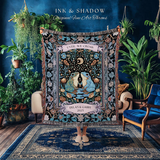 May include: A decorative throw blanket with a black background and a central design featuring two kissing frogs under a crescent moon. The blanket has a floral border and the text "UNTIL WE CROAK" and "DYLAN & GABBY 2025".