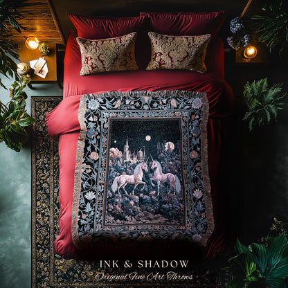 May include: A decorative throw blanket featuring a nighttime scene with two unicorns, a castle, and a full moon. The blanket is black with a floral border and the text "INK & SHADOW Original Fine Art Throws". The blanket is on a red bed with matching pillows.