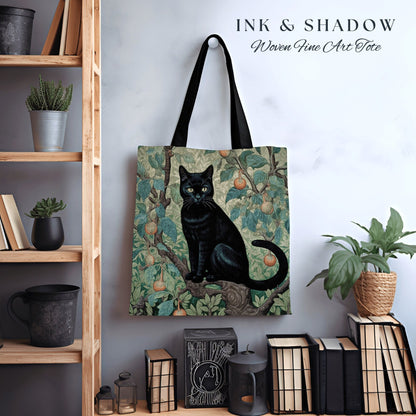 May include: A black cat sitting in a tree with green leaves and yellow pears. The cat is on a tote bag with the text "INK & SHADOW Woven Fine Art Tote".