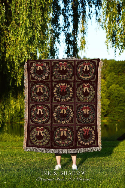 May include: A burgundy throw blanket featuring a repeating pattern of Christmas wreaths with red bows and green foliage. The blanket has a fringed edge and the text "INK & SHADOW Original Fine Art Throws" is visible at the bottom.