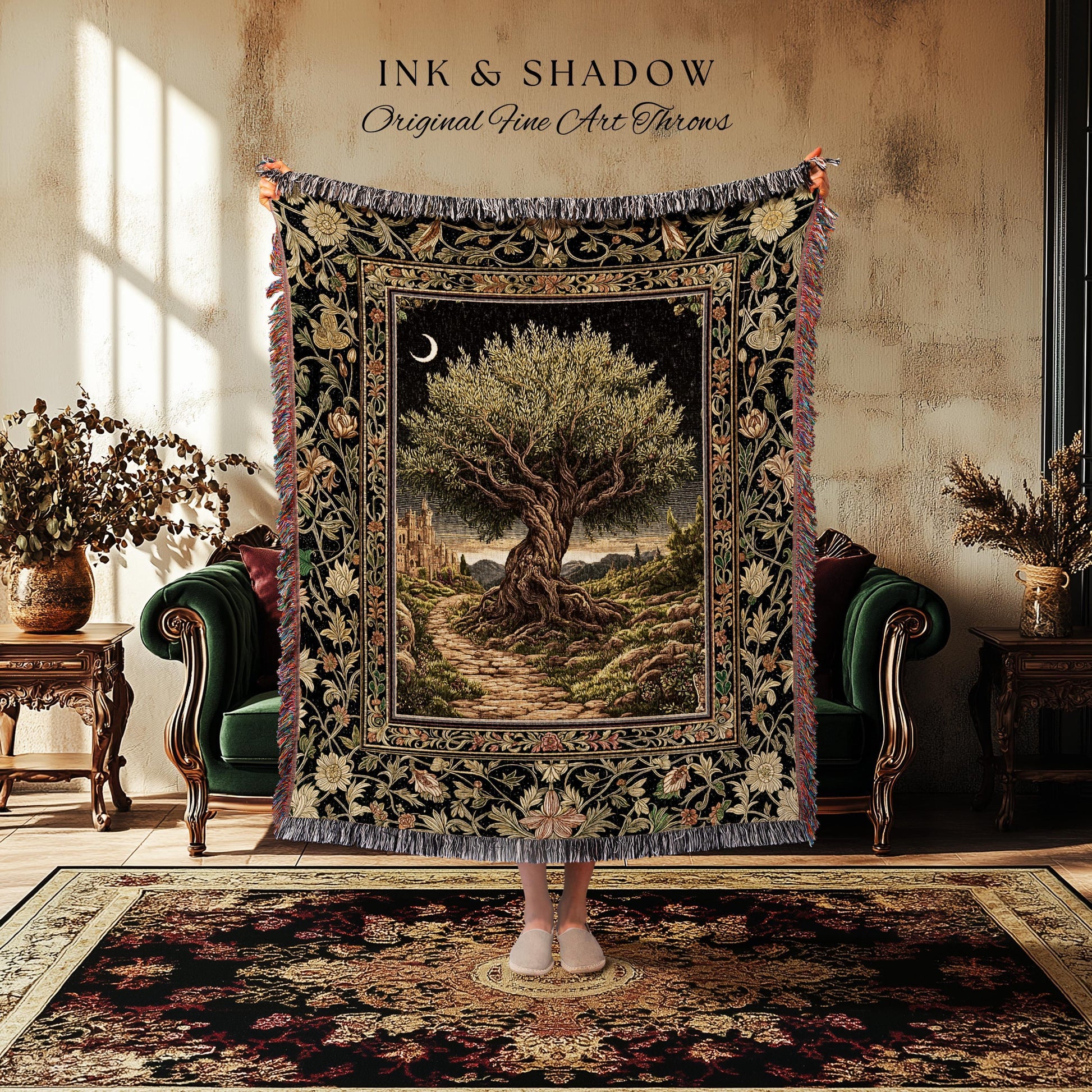 May include: A tapestry throw blanket with a detailed landscape scene featuring a large tree, a path, and a crescent moon. The blanket has a black border with floral and foliage patterns, and the text "INK & SHADOW Original Fine Art Throws".