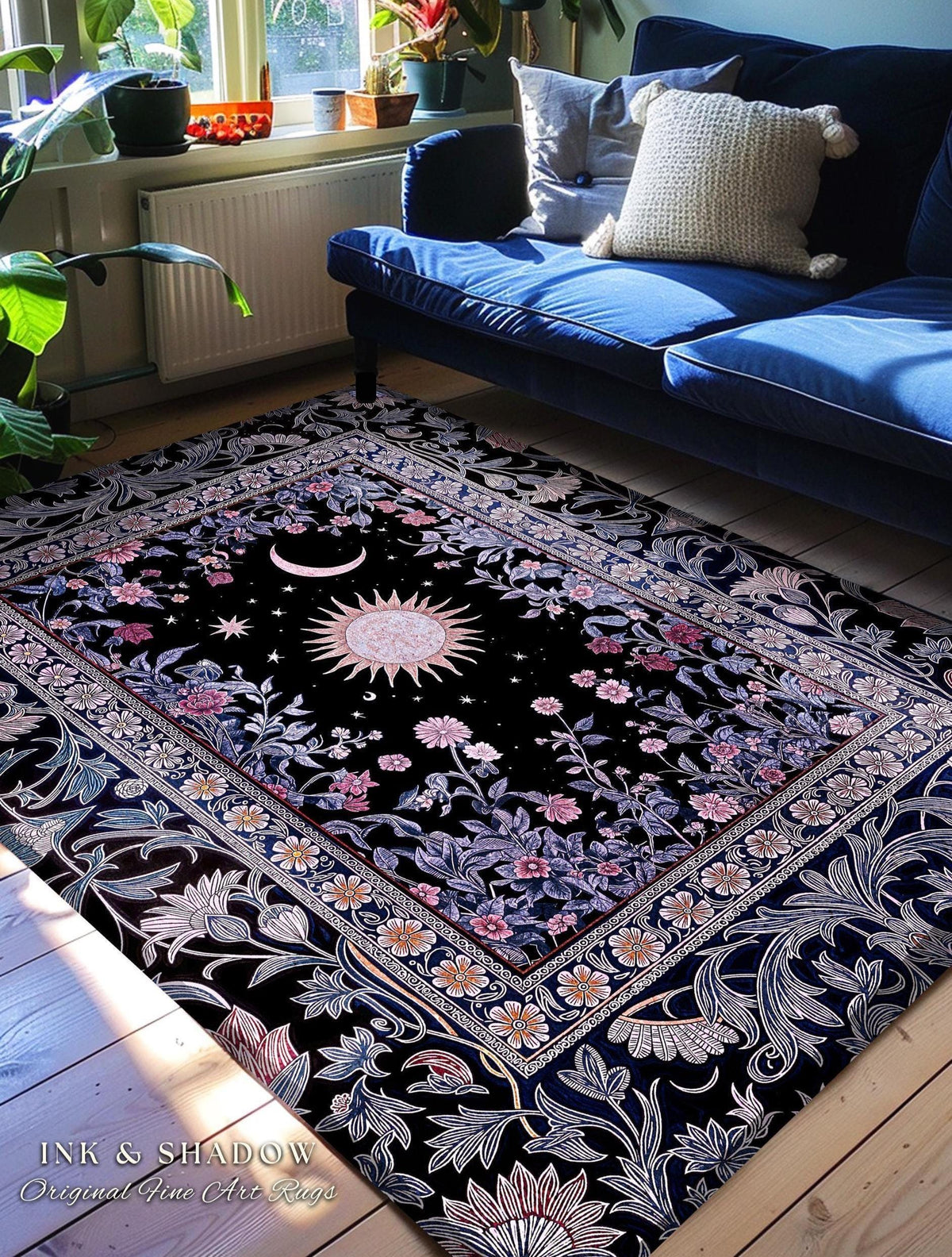 May include: Black area rug with a celestial design featuring a sun, moon, and stars. The rug has a floral border with pink and white flowers. The text "INK & SHADOW Original Fine Art Rugs" is visible in the bottom left corner.