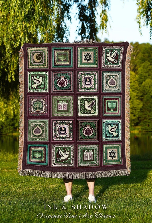 May include: A woven throw blanket with a repeating pattern of square panels. Each panel features a different design, including a dove, pomegranate, and Star of David, in shades of green, white, and burgundy. The blanket has a fringed edge and the text "INK & SHADOW Original Fine Art Throws".