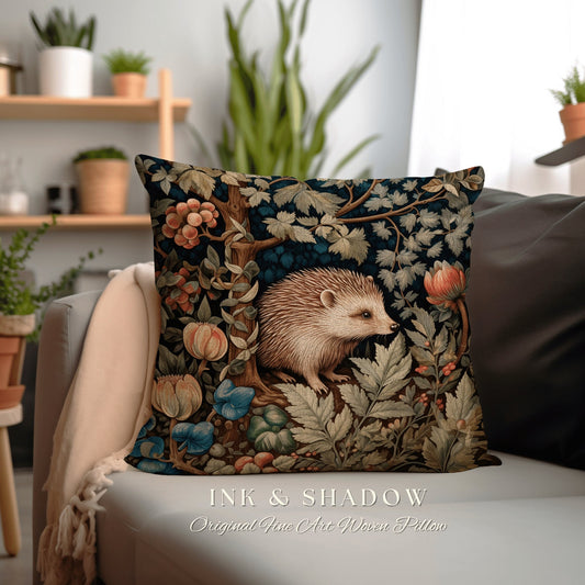 May include: A decorative throw pillow with a woven tapestry design featuring a hedgehog in a forest setting. The pillow has a dark blue background with intricate details of flowers, leaves, and a tree trunk. The hedgehog is brown and white and is surrounded by lush greenery. The text "INK & SHADOW Original Fine Art Woven Pillow" is printed below the image.