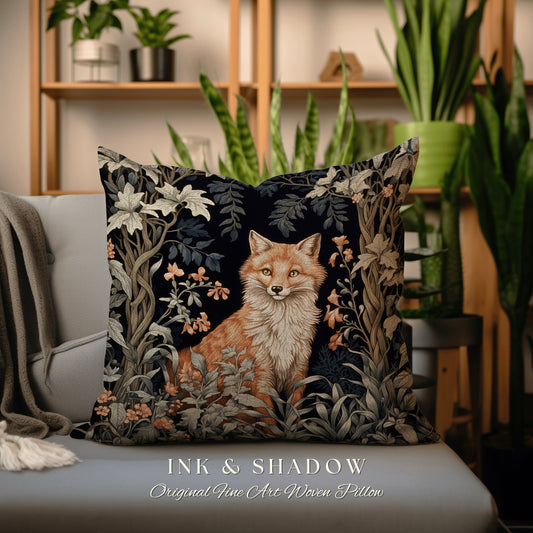 May include: A decorative pillow featuring a woven tapestry design of a fox in a forest setting. The pillow has a dark blue background with intricate details of leaves, flowers, and vines. The fox is a vibrant orange color with a white chest and a bushy tail. The text "INK & SHADOW Original Fine Art Woven Pillow" is printed below the image.