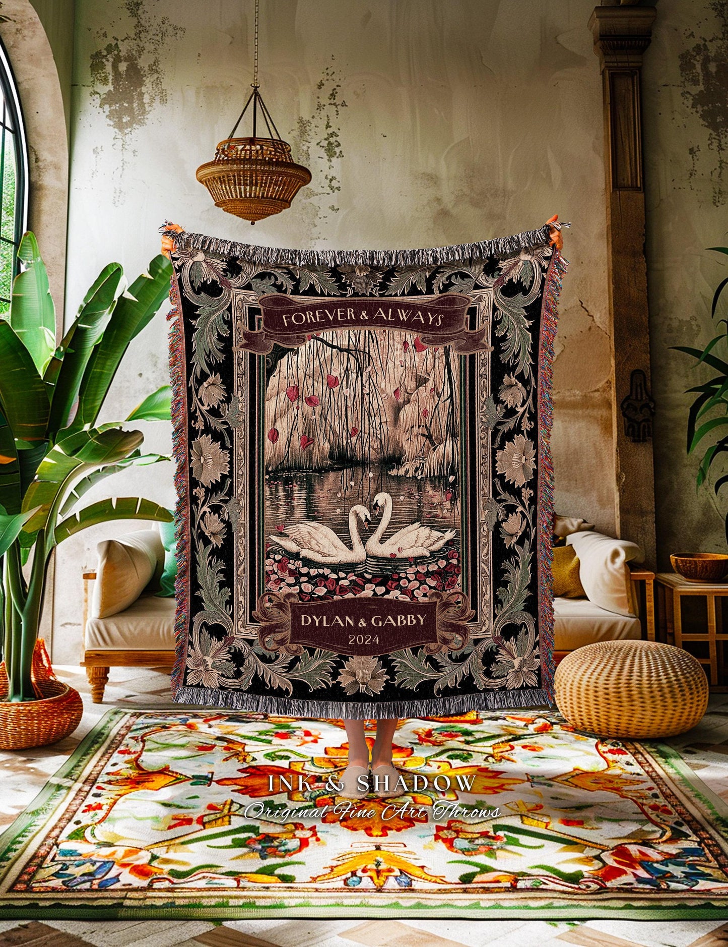 May include: A decorative woven throw blanket featuring a romantic scene with two swans on a lake. The blanket has a black background with floral and scrollwork borders. The text "FOREVER & ALWAYS" and "DYLAN & GABBY 2024" are displayed.