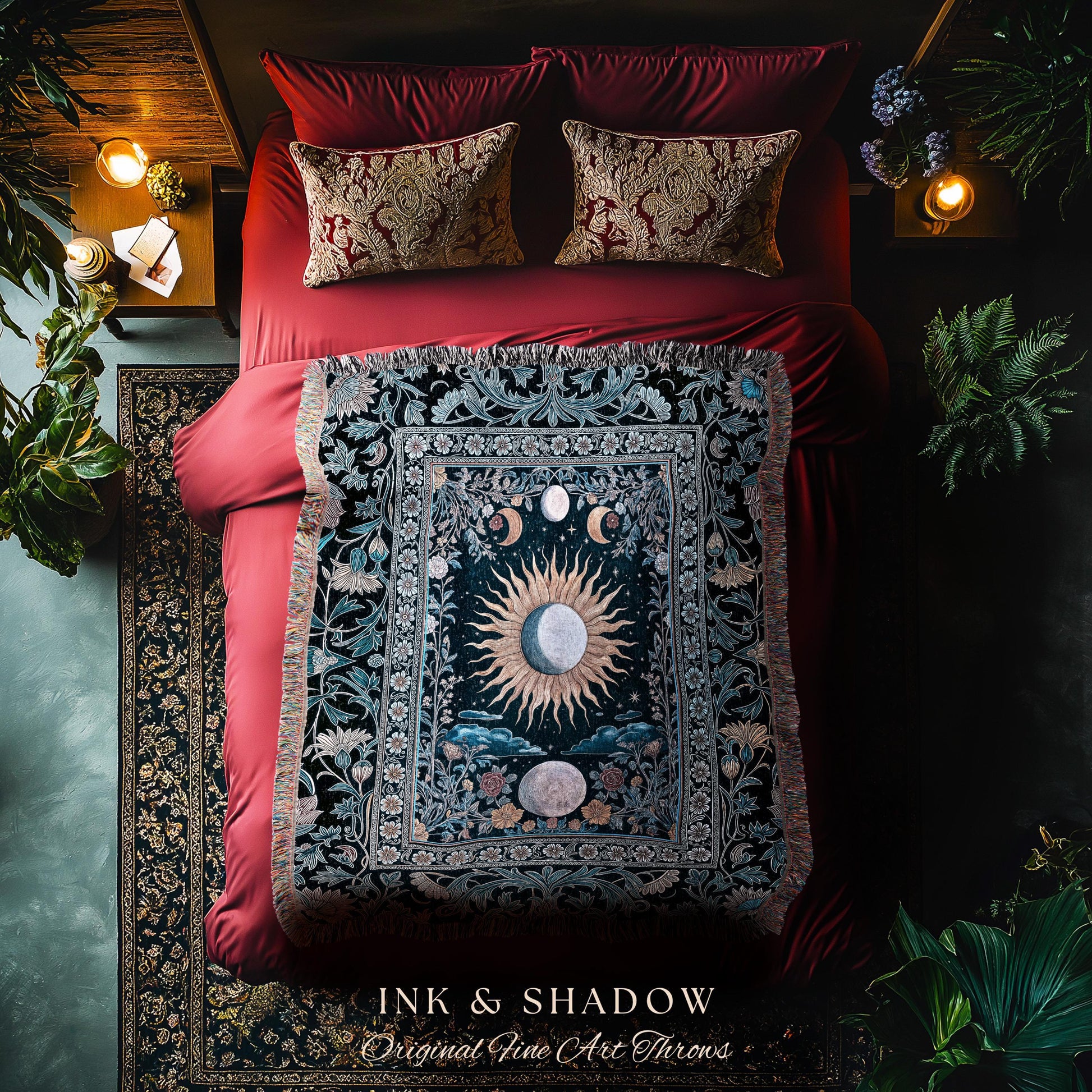 May include: A decorative throw blanket with a celestial design featuring a sun, moons, and floral elements. The blanket is displayed on a red bed with matching pillows. The text "INK & SHADOW Original Fine Art Throws" is visible at the bottom.