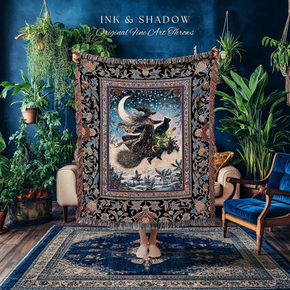 May include: A decorative throw blanket featuring a witch on a broomstick with a black cat, flying in front of a crescent moon and starry sky. The blanket has a black floral border and the text "INK & SHADOW Original Fine Art Throws".