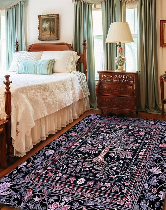 May include: A rectangular area rug with a black background and a detailed floral and tree design. The rug features a border with pink and purple flowers and leaves. The text "INK & SHADOW Original Fine Art Rugs" is visible on a wooden nightstand.