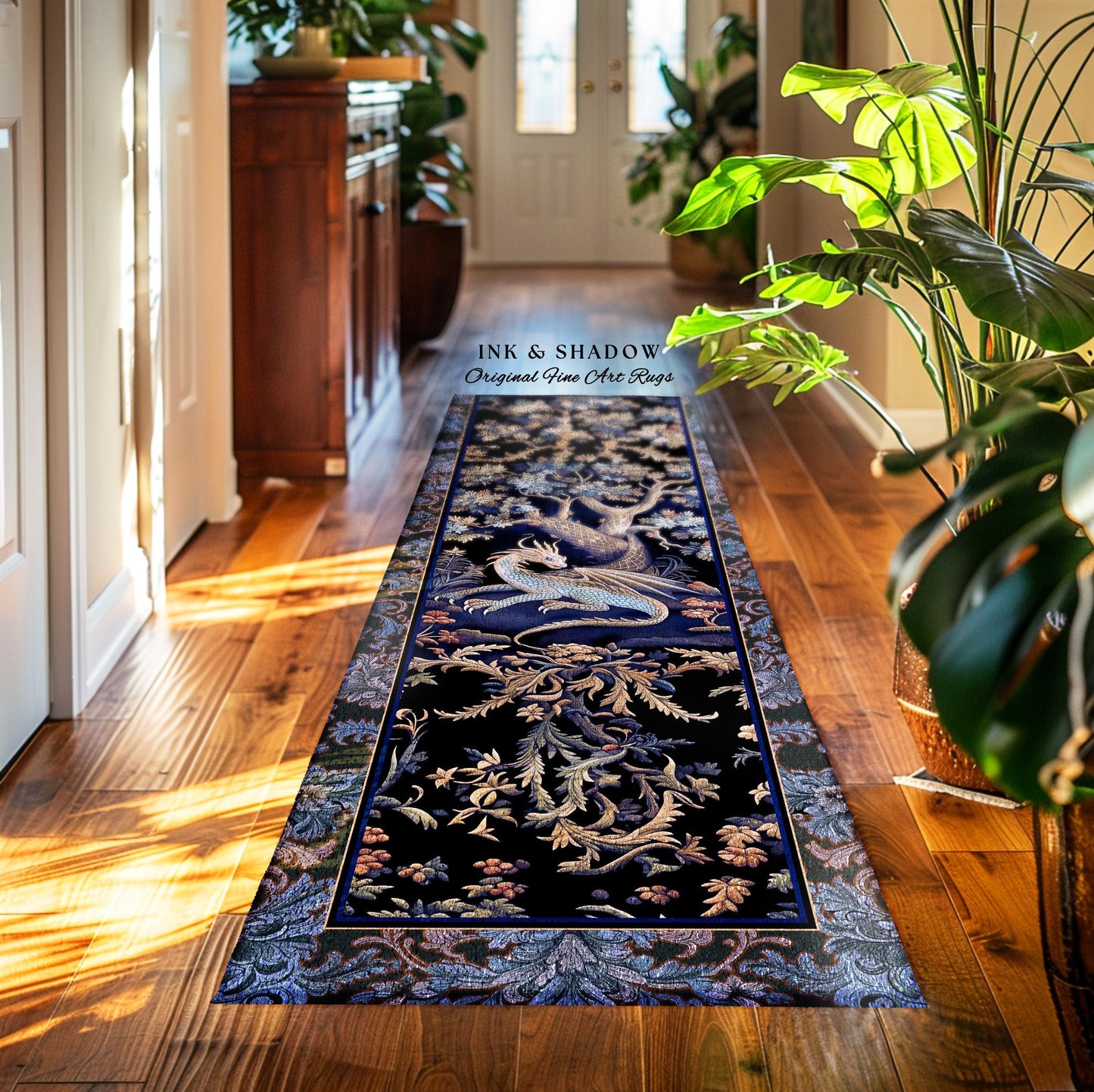 May include: A long, rectangular rug with a detailed dragon design. The rug features a dark blue background with a central dragon motif in white and gold, surrounded by floral patterns. The text "INK & SHADOW Original Fine Art Rugs" is visible.