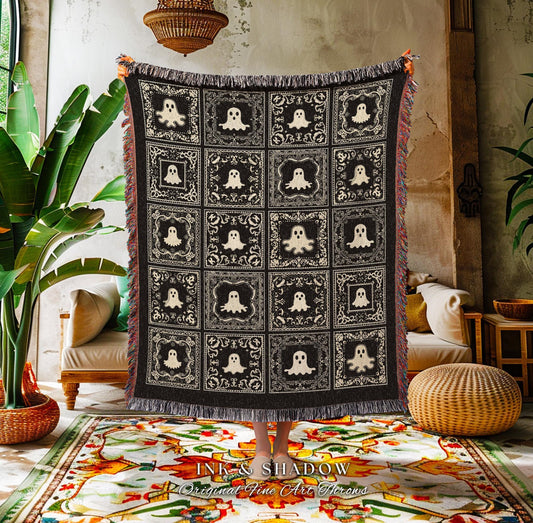 May include: A black and cream-colored throw blanket featuring a repeating pattern of ghost figures within decorative squares. The blanket has a fringed edge and is displayed indoors. The text "INK & SHADOW Original Fine Art Throws" is visible at the bottom.