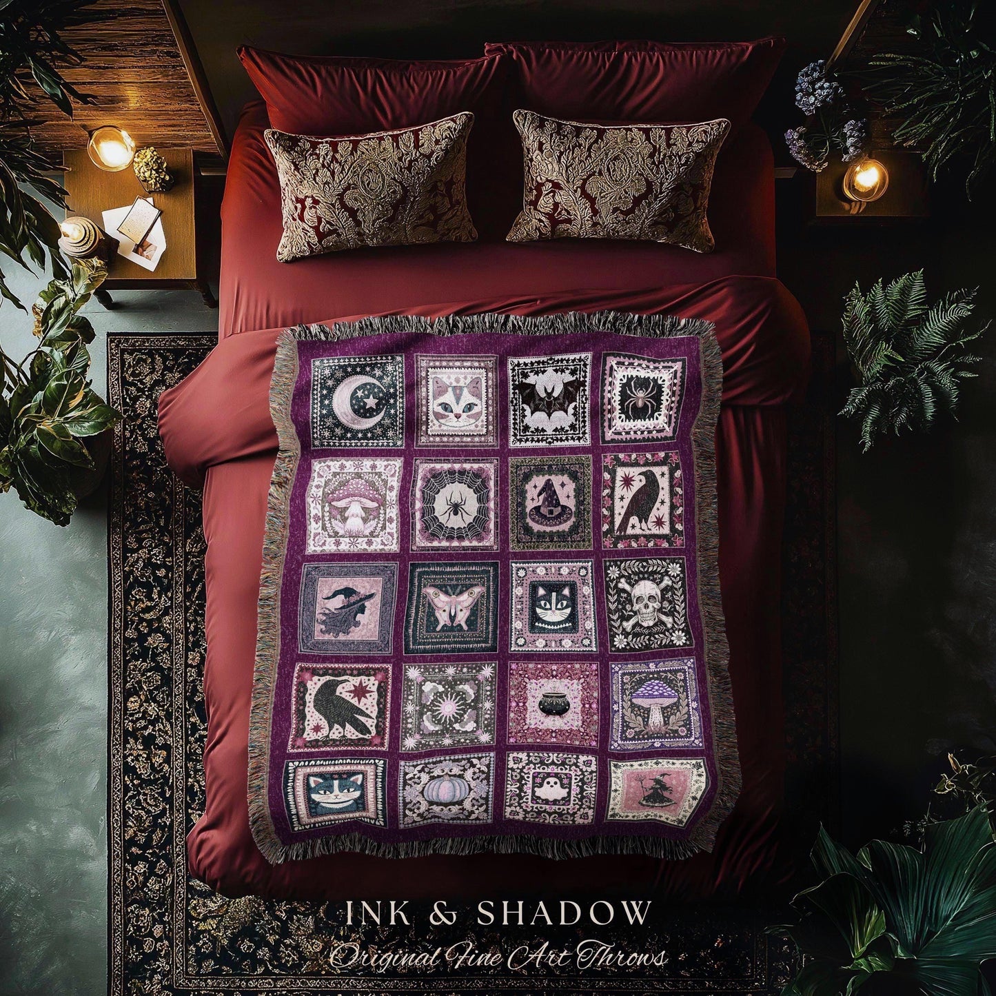 May include: A purple throw blanket with a patchwork design featuring various occult symbols like moons, bats, and skulls. The blanket is fringed and rests on a red bed with matching pillows. The text "INK & SHADOW Original Fine Art Throws" is at the bottom.