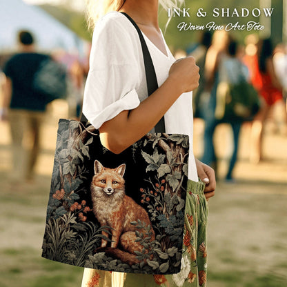 May include: A woven tote bag with a black strap and a colorful tapestry design featuring a fox in a forest setting. The text "INK & SHADOW Woven Fine Art Tote" is printed on the bag.