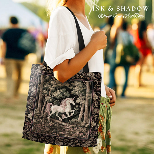 May include: A black tote bag with a woven tapestry design featuring a white unicorn in a forest setting. The bag has black straps and the text "INK & SHADOW Woven Fine Art Tote" is printed on the top.