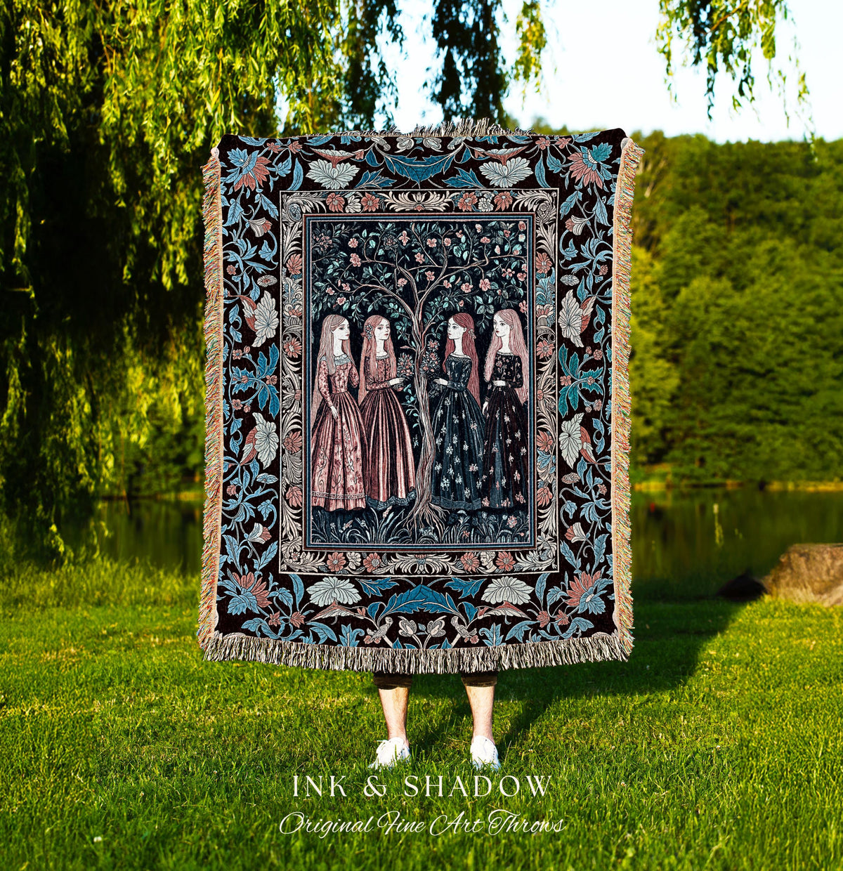 May include: A decorative throw blanket featuring a detailed illustration of four women standing near a tree. The blanket has a black background with floral and leaf patterns in blue, pink, and cream. The text "INK & SHADOW Original Fine Art Throws" is at the bottom.
