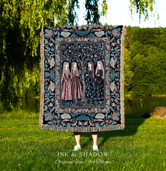 May include: A decorative throw blanket featuring a detailed illustration of four women standing near a tree. The blanket has a black background with floral and leaf patterns in blue, pink, and cream. The text "INK & SHADOW Original Fine Art Throws" is at the bottom.