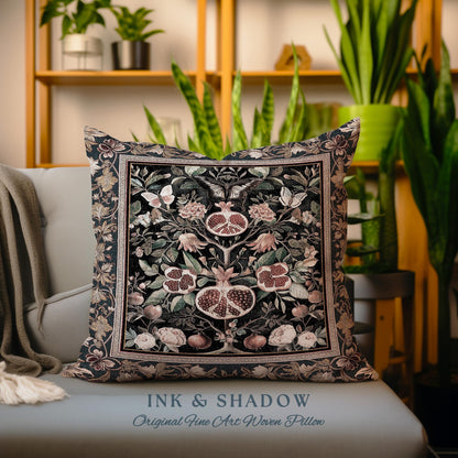 May include: A decorative throw pillow with a woven tapestry design featuring a pomegranate tree with intricate details. The pillow is black with shades of pink, green, and gold. The text "INK & SHADOW Original Fine Art Woven Pillow" is printed on the bottom of the pillow.