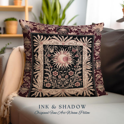 May include: A decorative pillow with a woven tapestry design featuring a sun and moon with floral accents. The pillow is burgundy with black and gold accents. The text "INK & SHADOW Original Fine Art Woven Pillow" is printed below the pillow.