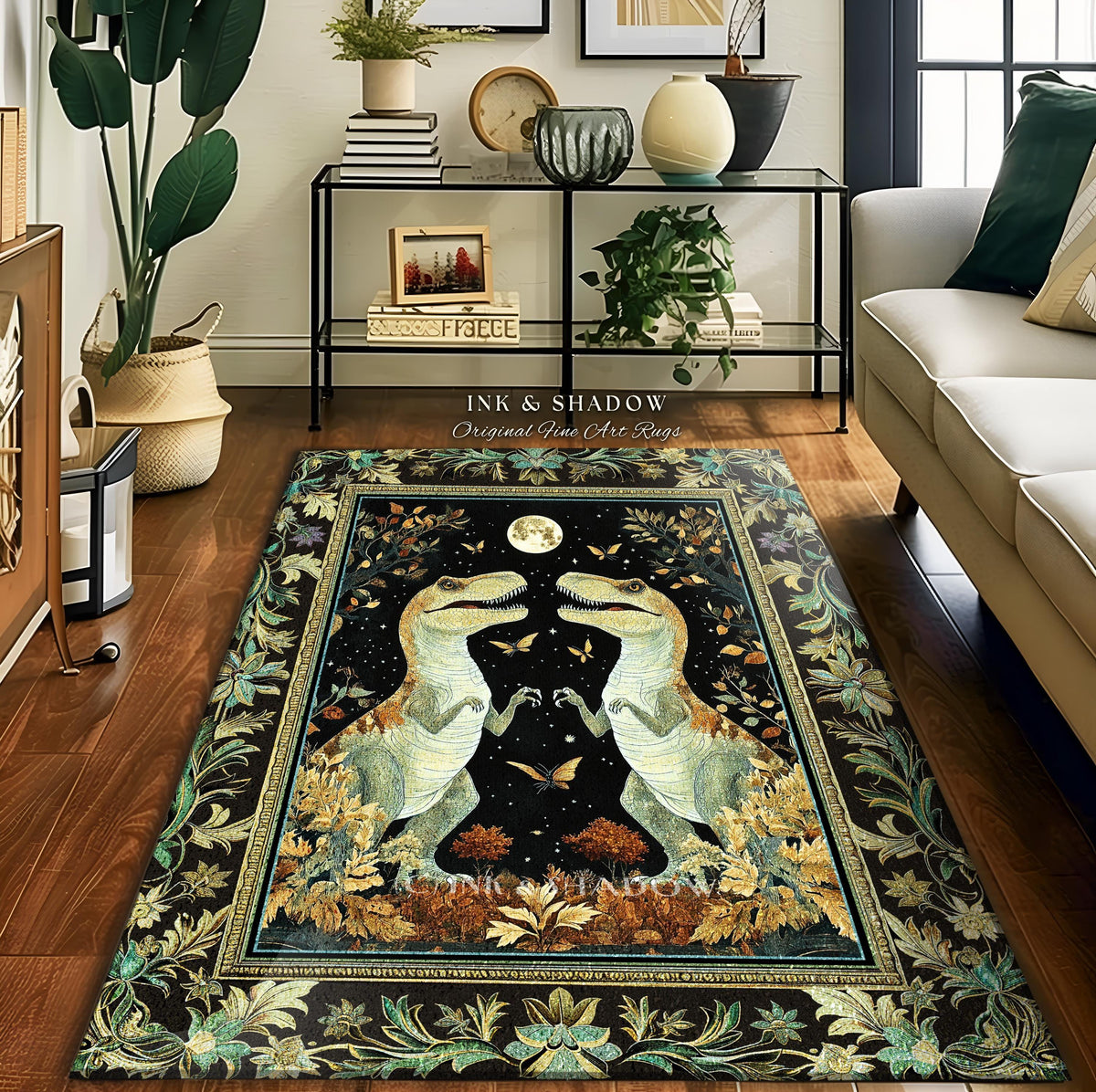 May include: A rectangular area rug with a black background featuring two dinosaurs facing each other under a full moon. The rug has a decorative border with floral and leaf patterns in shades of green, gold, and brown. The text "INK & SHADOW Original Fine Art Rugs" is visible.