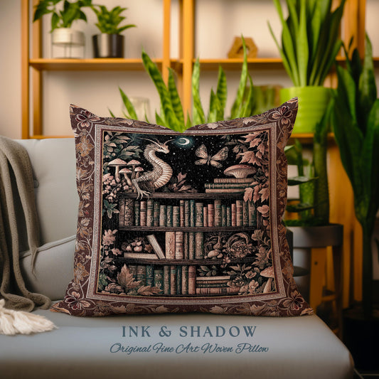 May include: A decorative pillow with a tapestry-style design featuring a dragon, a bookshelf filled with books, and a moon and stars. The pillow has a brown background with gold accents and the text "Ink & Shadow Original Fine Art Woven Pillow".